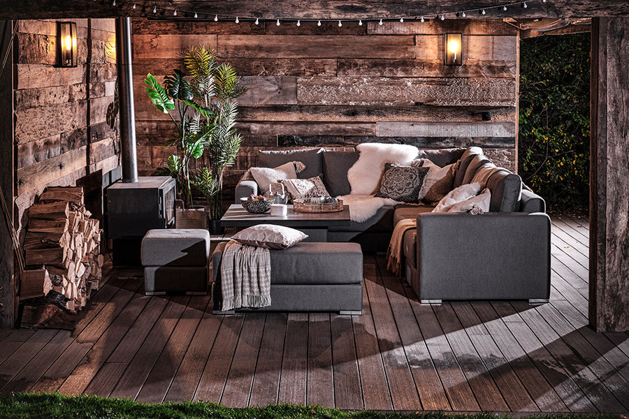 Ascot modular sofa upholstered in fully waterproof grey fabric in a cosy wood house at night.